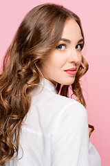 Image showing The happy business woman standing and smiling against pink background.