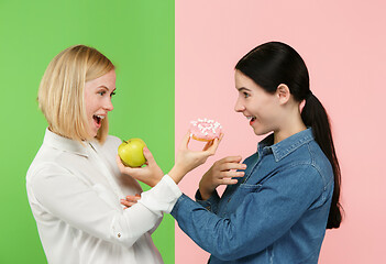 Image showing Diet. Dieting concept. Healthy Food. Beautiful Young Women choosing between fruits and unhelathy cake