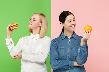 Image showing Diet. Dieting concept. Healthy Food. Beautiful Young Women choosing between fruits and unhelathy fast food