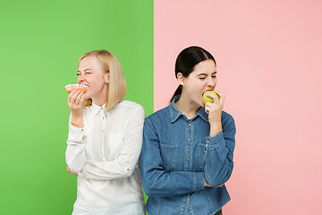 Image showing Diet. Dieting concept. Healthy Food. Beautiful Young Women choosing between fruits and unhelathy cake