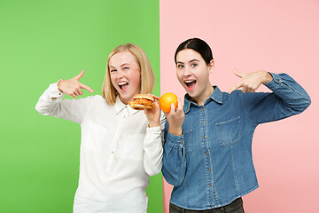 Image showing Diet. Dieting concept. Healthy Food. Beautiful Young Women choosing between fruits and unhelathy fast food