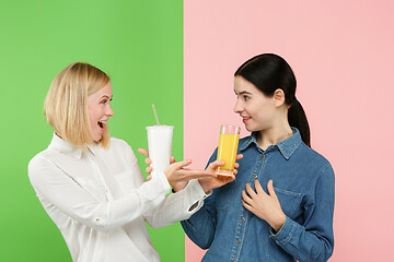Image showing Diet. Dieting concept. Healthy Food. Beautiful Young Women choosing between fruit orange juice and unhelathy carbonated sweet drink