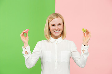 Image showing Young beautiful woman holding macaroons pastry in her hands