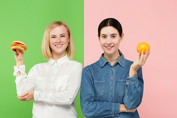 Image showing Diet. Dieting concept. Healthy Food. Beautiful Young Women choosing between fruits and unhelathy fast food