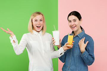 Image showing Diet. Dieting concept. Healthy Food. Beautiful Young Women choosing between fruit orange juice and unhelathy carbonated sweet drink