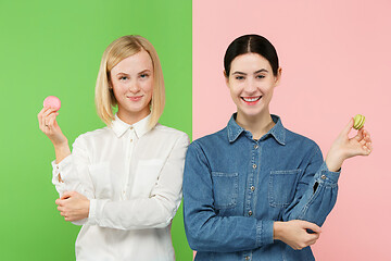 Image showing Young beautiful women holding macaroons pastry in her hands