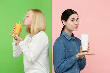 Image showing Diet. Dieting concept. Healthy Food. Beautiful Young Women choosing between fruit orange juice and unhelathy carbonated sweet drink