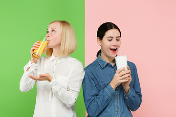 Image showing Diet. Dieting concept. Healthy Food. Beautiful Young Women choosing between fruit orange juice and unhelathy carbonated sweet drink