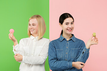 Image showing Young beautiful women holding macaroons pastry in her hands