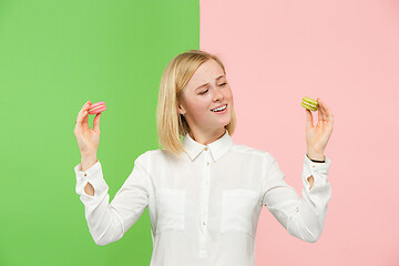 Image showing Young beautiful woman holding macaroons pastry in her hands