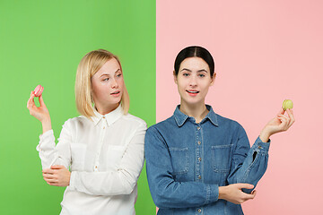 Image showing Young beautiful women holding macaroons pastry in her hands