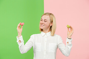 Image showing Young beautiful woman holding macaroons pastry in her hands