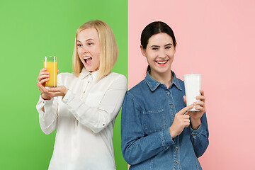 Image showing Diet. Dieting concept. Healthy Food. Beautiful Young Women choosing between fruit orange juice and unhelathy carbonated sweet drink