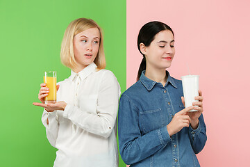 Image showing Diet. Dieting concept. Healthy Food. Beautiful Young Women choosing between fruit orange juice and unhelathy carbonated sweet drink