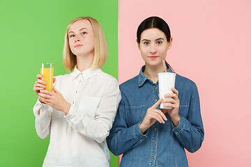 Image showing Diet. Dieting concept. Healthy Food. Beautiful Young Women choosing between fruit orange juice and unhelathy carbonated sweet drink