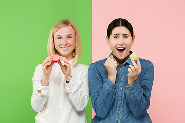 Image showing Young beautiful women holding macaroons pastry in her hands