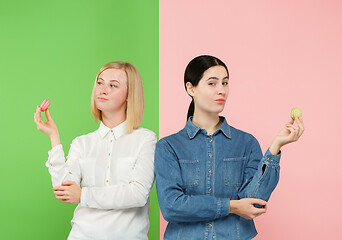 Image showing Young beautiful women holding macaroons pastry in her hands