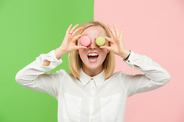 Image showing Young beautiful woman holding macaroons pastry in her hands