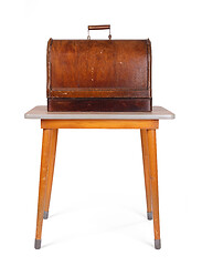 Image showing Antique, vintage sewing machine (wooden cover) on an old table