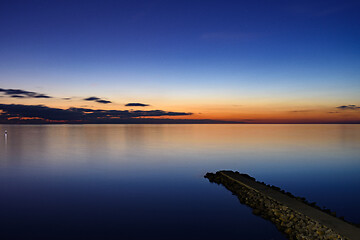 Image showing Seascape after sunset, breakwater goes from the coast