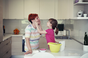 Image showing Mother and daughter playing and preparing dough in the kitchen.