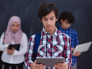 Image showing Arab teenagers group working on laptop and tablet computer