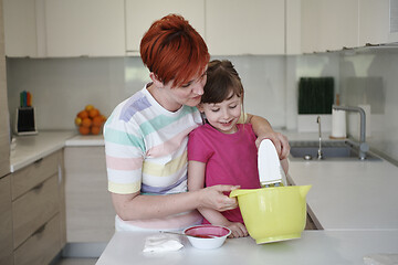 Image showing Mother and daughter playing and preparing dough in the kitchen.