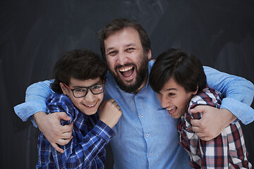 Image showing happy father hugging sons