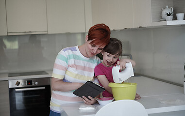 Image showing Mother and daughter playing and preparing dough in the kitchen.