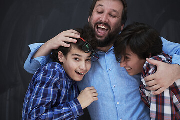 Image showing happy father hugging sons