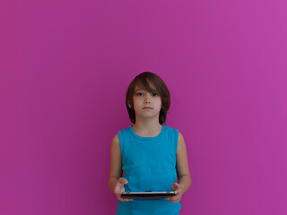 Image showing Little Arabian boy using  on digital tablet pink background