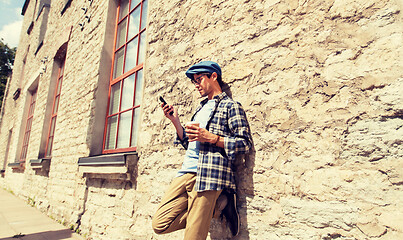 Image showing man with smartphone drinking coffee on city street