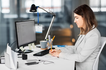 Image showing businesswoman with notebook working at office
