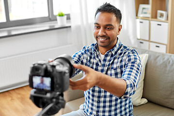 Image showing indian male video blogger adjusting camera at home