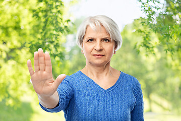 Image showing senior woman in blue sweater making stop gesture