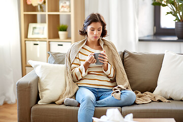 Image showing sad sick young woman drinking hot tea at home