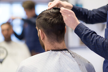 Image showing male hairdresser cutting hair at barbershop