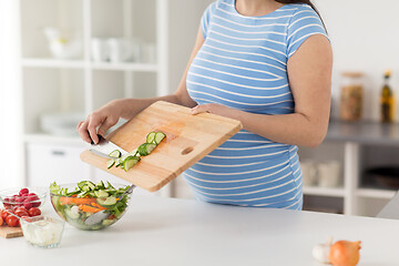 Image showing close up of pregnant woman cooking food at home