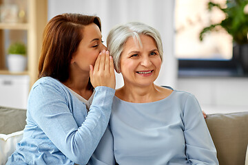 Image showing adult daughter whispering to senior mother at home