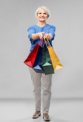 Image showing senior woman with shopping bags over grey