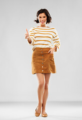 Image showing woman in pullover, skirt and shoes shows thumbs up