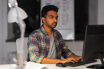 Image showing creative man with computer working at night office