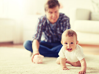 Image showing happy father with baby and piggy bank at home