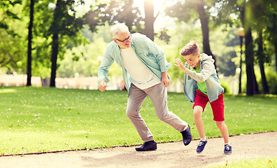 Image showing grandfather and grandson racing at summer park