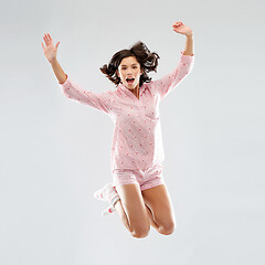 Image showing happy woman in pajama jumping high