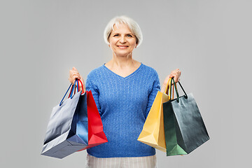 Image showing senior woman with shopping bags over grey