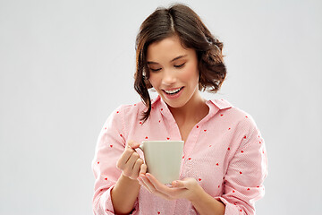 Image showing young woman in pajama drinking coffee from mug