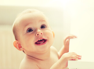 Image showing happy little baby boy or girl at home looking up