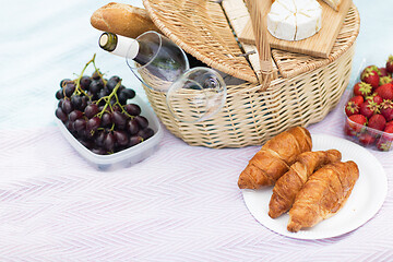 Image showing picnic basket, food and wine glasses on blanket