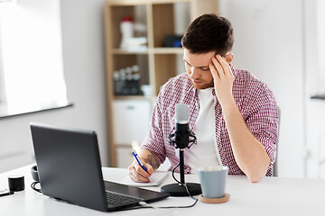 Image showing audio blogger with laptop, microphone and notebook